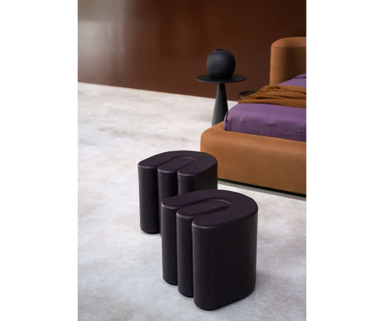 Baxter Adel leather pouf with sculptural curved design.