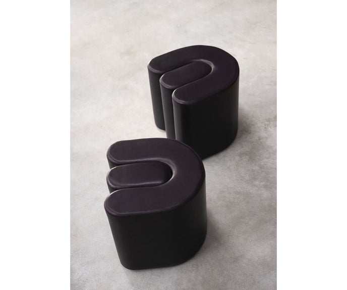 Baxter Adel leather pouf with sculptural curved design.