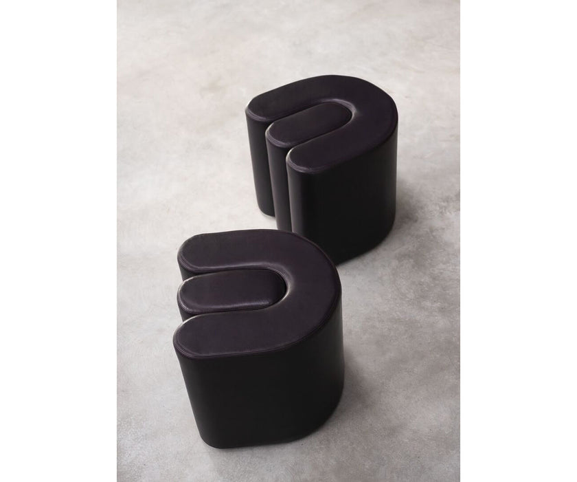 Baxter Adel leather pouf with sculptural curved design.