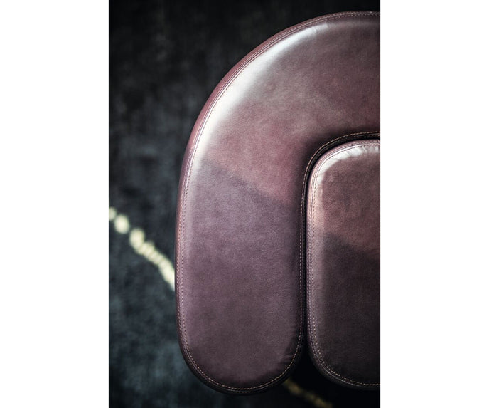 Baxter Adel leather pouf with sculptural curved design.