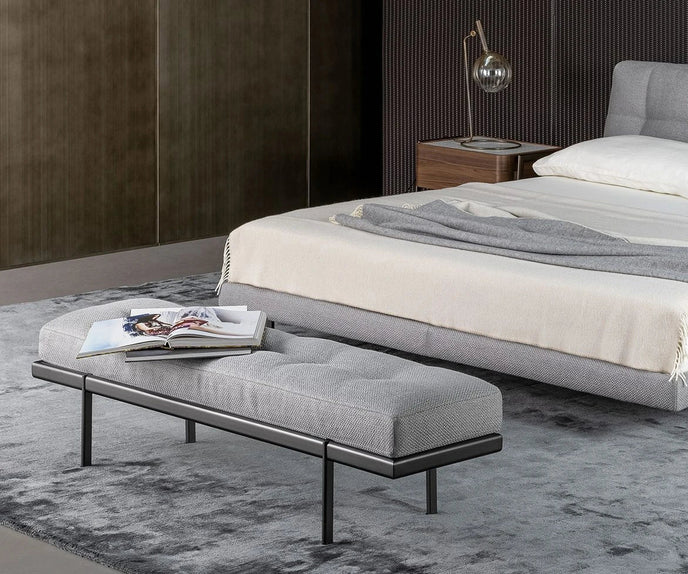 Bonaldo James upholstered bedroom bench with padded seat and painted metal base in a contemporary bedroom setting.