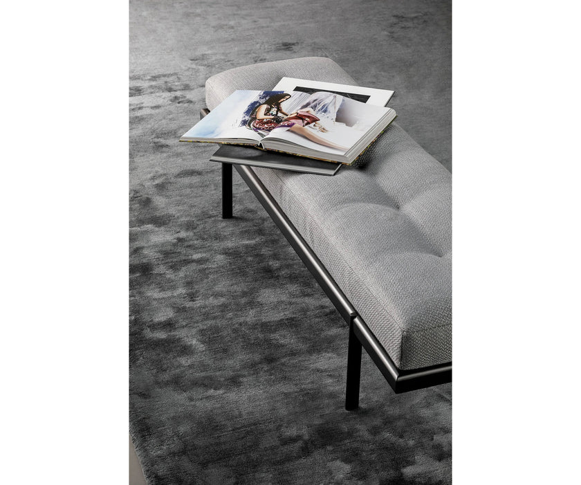 Bonaldo James upholstered bedroom bench with padded seat and painted metal base in a contemporary bedroom setting.