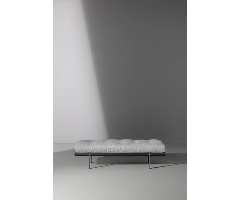 Bonaldo James upholstered bedroom bench with padded seat and painted metal base in a contemporary bedroom setting.