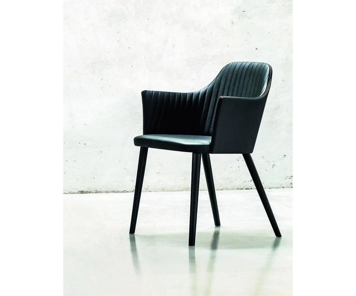Break 1645 dining armchair by Bross with quilted upholstery and beechwood legs Casa Design Group