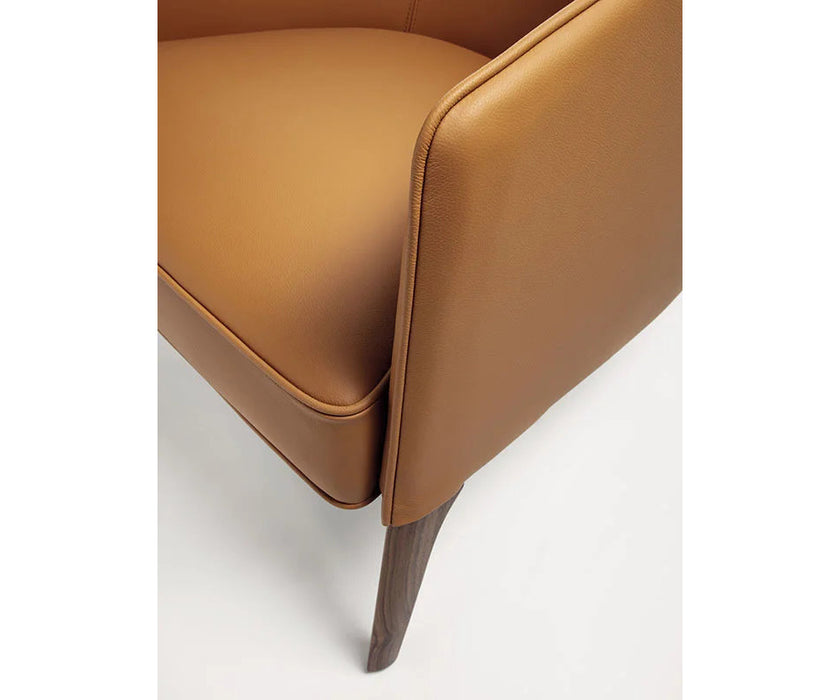 Frigerio Jackie upholstered armchair with solid ashwood legs and tailored fabric or leather upholstery, available at Casa Design Group.