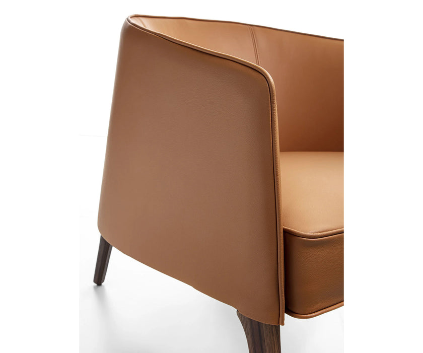 Frigerio Jackie upholstered armchair with solid ashwood legs and tailored fabric or leather upholstery, available at Casa Design Group.