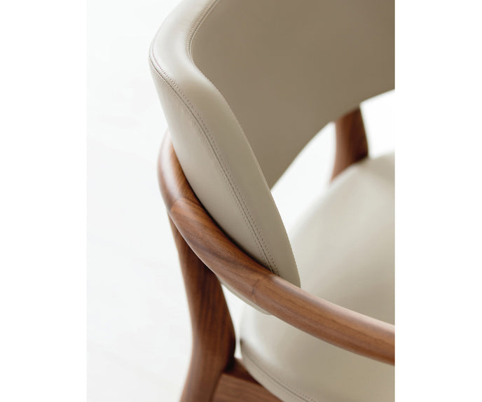 Porada Nissa dining armchair with a solid Canaletta walnut frame and fabric or leather upholstery | Casa Design Group